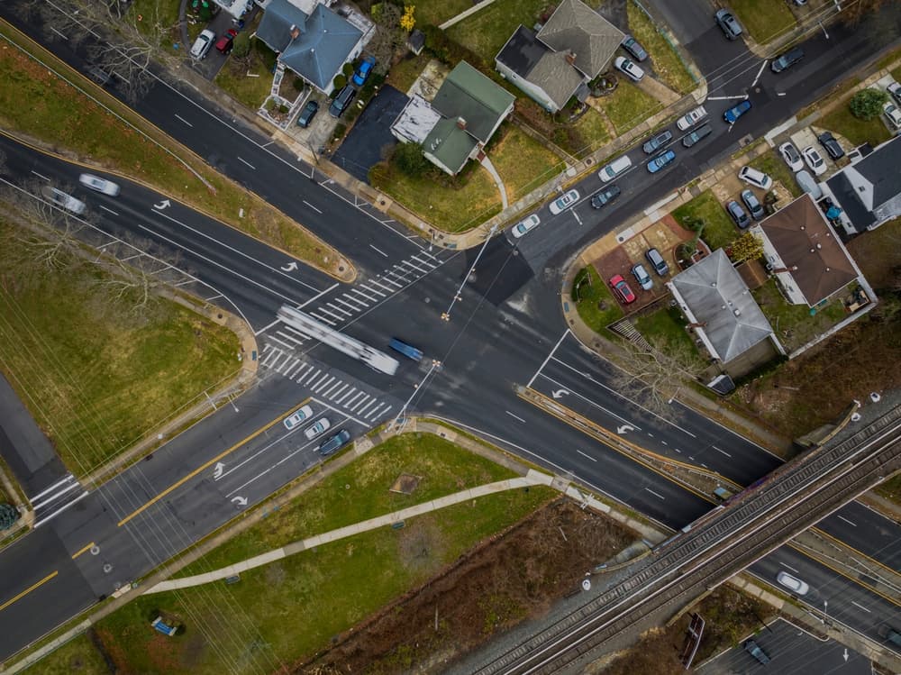 Cloudy day aerial view of a Long Island, New York suburban neighborhood intersection from above.