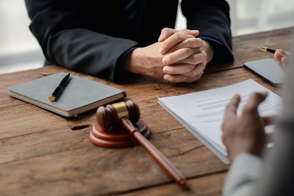 A client listens to a lawyer discussing an embezzlement case, preparing evidence for a lawsuit.