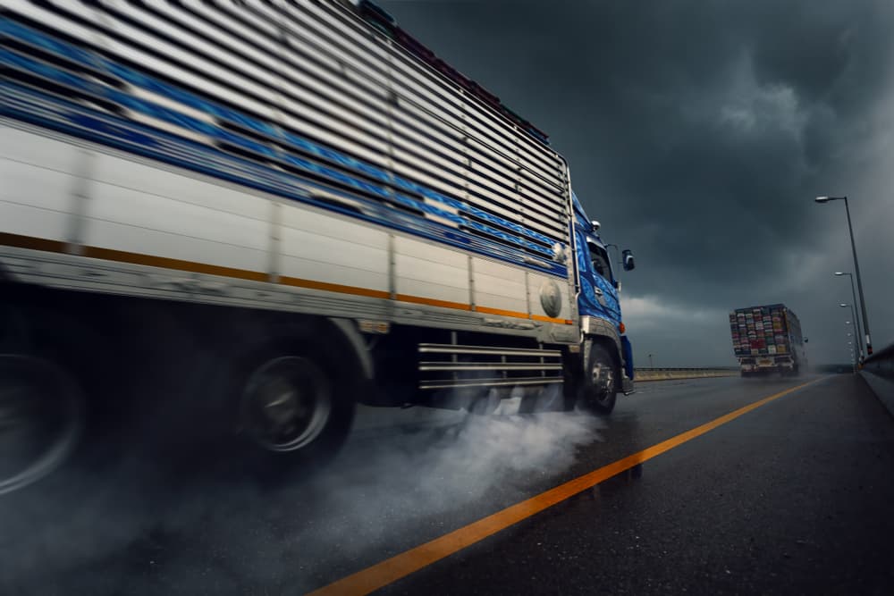 Truck speeding on wet road in bad weather conditions after heavy rain.