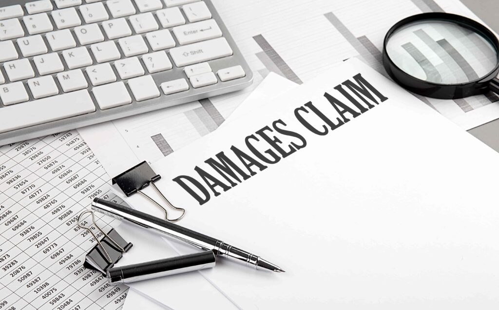 Damages claim document with financial charts, calculator, and magnifying glass for legal compensation case.