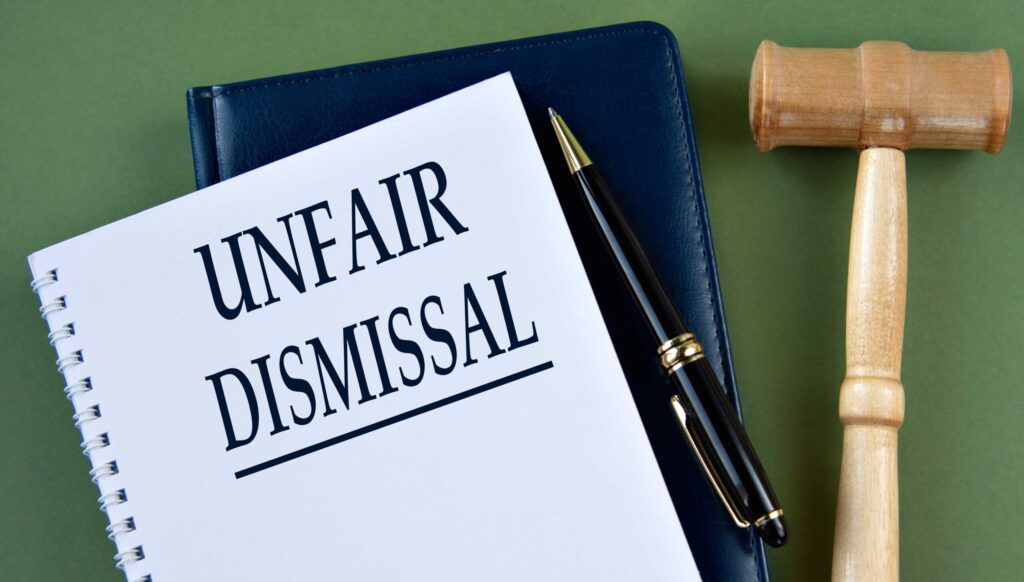 Documento legal de despido injustificado con un mazo que representa un reclamo por despido improcedente. Documento legal de despido injustificado con un mazo que representa un reclamo por despido improcedente.