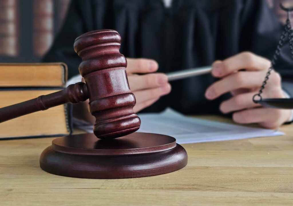 Mazo de juez sobre un escritorio en una sala de tribunal, que representa los procesos legales y las decisiones en demandas civiles. Mazo de juez sobre un escritorio en una sala de tribunal, que representa los procesos legales y las decisiones en demandas civiles.