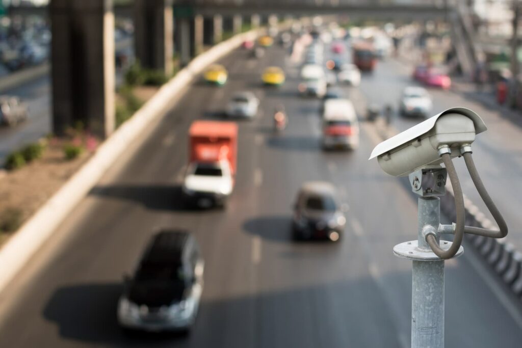 Traffic surveillance camera monitoring vehicles on a busy road